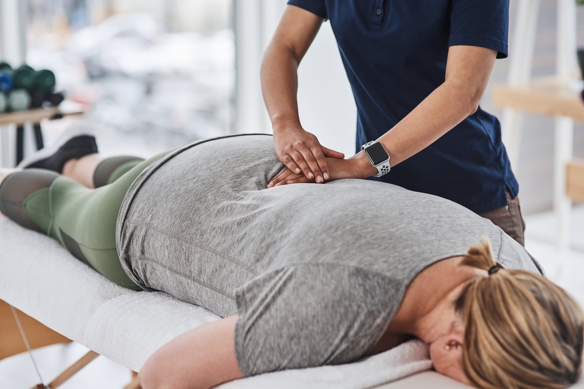 Mature woman getting back treatment from a physiotherapist at a clinic