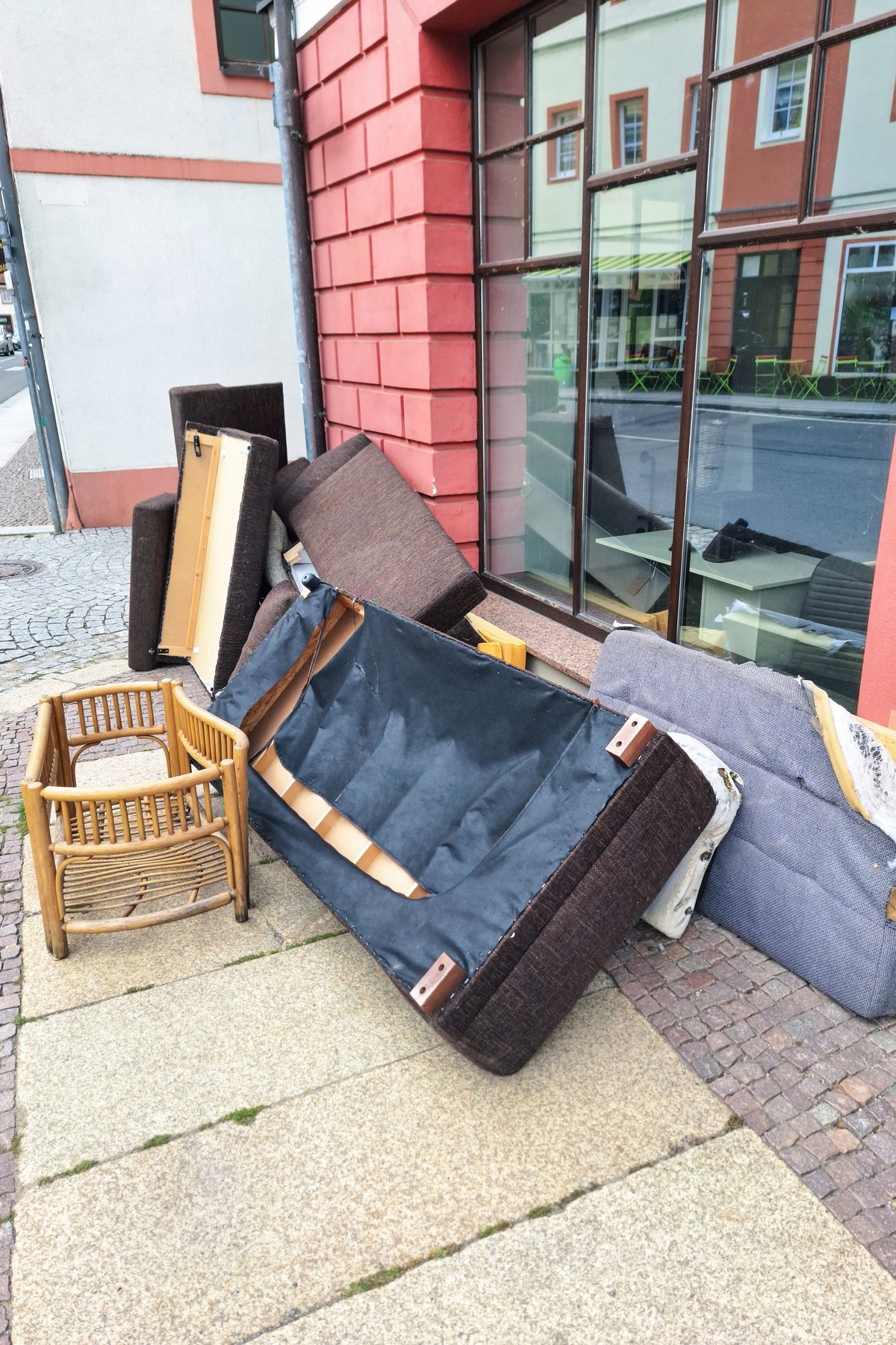 Discarded furniture on city sidewalk highlighting the need for junk removal services