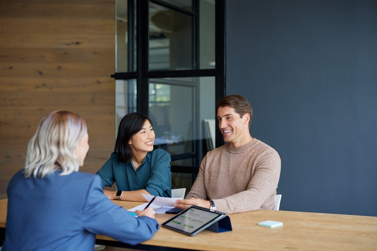 Smiling multiethnic couple receiving financial guidance from advisor