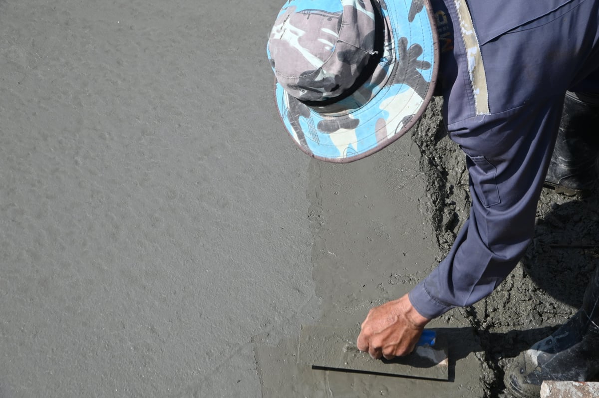 Concrete workers pouring and finishing a smooth concrete floor